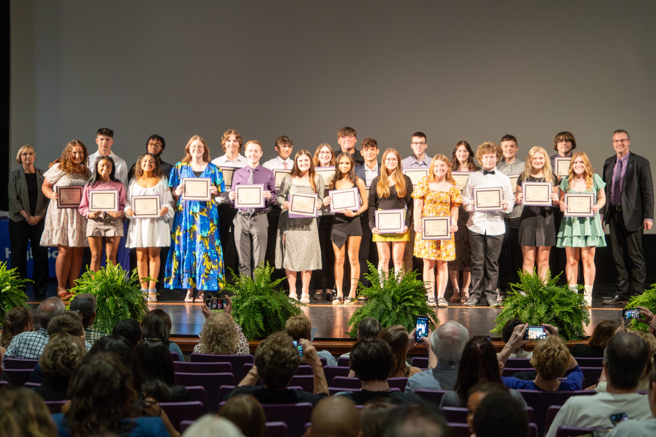Barberton Community Foundation 2024 Cum Laude Scholarship Recipients: 25 students stand on stage holding certificates